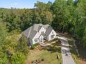 Stunning aerial view of the home showing its landscaped yard and long driveway surrounded by lush trees at 60 Citori Ct, Pittsboro, NC 27312