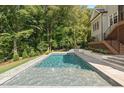 Beautiful in-ground pool with a stone deck and manicured landscaping in the backyard at 60 Citori Ct, Pittsboro, NC 27312