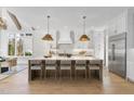 Open kitchen features a large quartz island with seating and pendant lights and abundant cabinet storage at 701 Dartmouth Rd, Raleigh, NC 27609