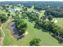 Aerial view showcasing a golf course with ponds and tree-lined fairways at 102 Preston Pines Dr, Cary, NC 27513