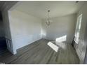 Spacious dining room with wood-look floors and a modern chandelier at 1528 Maelyn Way, Fuquay Varina, NC 27526
