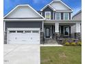 Charming two-story home with a three car garage, stone accents and well manicured lawn at 1528 Maelyn Way, Fuquay Varina, NC 27526