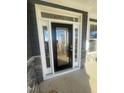Elegant front door with glass panels, white trim, and stone accents creating an inviting entrance at 1528 Maelyn Way, Fuquay Varina, NC 27526
