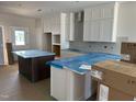 Bright kitchen showcasing white cabinets, an island, and modern finishes at 2408 Adrift Road, Fuquay Varina, NC 27526