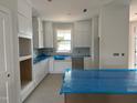 Bright kitchen featuring custom white cabinetry, a farmhouse sink, and an island with room for seating at 2412 Adrift Road, Fuquay Varina, NC 27526