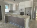 Spacious kitchen features white cabinets, ample counter space, and a large center island, perfect for cooking at 2404 Adrift Rd, Fuquay Varina, NC 27526