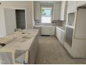 Well-lit kitchen with white cabinets and an island, providing lots of storage and food prep space at 2404 Adrift Rd, Fuquay Varina, NC 27526