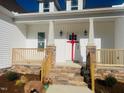 Front entrance with stone steps, red bow, and white columns at 119 Seahawk Way, Zebulon, NC 27597
