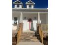 Front entrance with stone steps, red bow, and white columns at 119 Seahawk Way, Zebulon, NC 27597