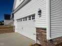 White garage with stone accents and carriage-style garage door at 119 Seahawk Way, Zebulon, NC 27597