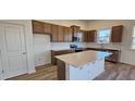 Modern kitchen featuring wood cabinets, stainless steel appliances, a subway tile backsplash, and an island at 159 Robert Howe Dr, Fuquay Varina, NC 27526