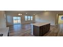 Open-concept living area with hardwood floors, large windows, and access to the kitchen at 159 Robert Howe Dr, Fuquay Varina, NC 27526