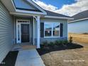 Charming home showcasing newly planted landscaping with a covered front entry at 210 Drayton Hall Ln, Sanford, NC 27330