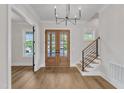 Bright foyer features hardwood floors, iron stair railings, and stylish chandelier at 113 S Ennis St, Fuquay Varina, NC 27526