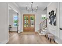Bright foyer featuring hardwood floors, a modern chandelier, and staircase at 113 S Ennis St, Fuquay Varina, NC 27526