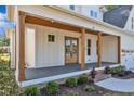 Charming front porch with wooden columns and a gray composite floor with nice landscaping at 113 S Ennis St, Fuquay Varina, NC 27526
