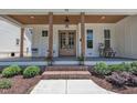 Inviting front porch with rocking chairs, brick steps, and stylish double doors at 113 S Ennis St, Fuquay Varina, NC 27526