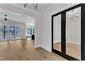 Open living area with hardwood floors, black french doors, and open access to kitchen at 113 S Ennis St, Fuquay Varina, NC 27526