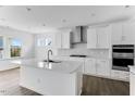 Bright kitchen with a large island, stainless steel hood, built in appliances, and hardwood floors at 929 Kinglet House Rd, Knightdale, NC 27545