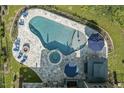 Stunning aerial view of the pool, spa, firepit, outdoor kitchen, and patio area at 133 Synandra Ln, Holly Springs, NC 27540