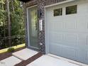 Modern townhome featuring a grey brick facade, an attached garage, and an inviting olive front door at 2126 Opulent Oaks Ln # 14, Durham, NC 27713