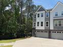 Charming townhome with gray and white siding, large windows, and an attached two-car garage on a sunny day at 2126 Opulent Oaks Ln # 14, Durham, NC 27713
