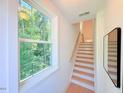 Bright, modern staircase featuring natural light from the nearby window and a view of the bordering woods at 2126 Opulent Oaks Ln # 14, Durham, NC 27713