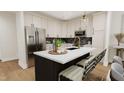 Bright, airy kitchen with stainless steel appliances, black accents, and a marble countertop island with seating at 4031 Elk Crk Ln, Raleigh, NC 27612