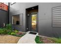 Modern home's front entrance featuring a glass door, clean lines, and professional landscaping at 1511 Malta Ave, Raleigh, NC 27610