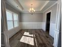 Formal dining room features hardwood floors, wainscoting, and a chandelier at 16 Dark Night Ln, Zebulon, NC 27597