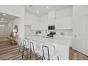 Modern kitchen with white cabinets, quartz countertops, an island with seating, and stainless steel appliances at 222 Chestnut Oak Ln, Lillington, NC 27546