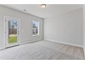 Bright bedroom with neutral carpet, a window, and a glass door leading to an outdoor space at 2038 Fishamble St, Fuquay Varina, NC 27526
