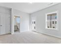 Bright, carpeted bedroom with en-suite bathroom, featuring large windows and neutral colors at 2042 Fishamble St, Fuquay Varina, NC 27526