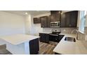 Well-lit kitchen featuring a center island, stainless steel appliances, and stylish gray backsplash at 566 John Stark Dr, Fuquay Varina, NC 27526