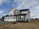 Inviting two-story home featuring a spacious three-car garage and neutral-colored exterior at 57 Bering Cir, Angier, NC 27501
