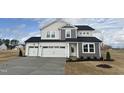 Inviting two-story home featuring a spacious three-car garage and neutral-colored exterior at 57 Bering Cir, Angier, NC 27501