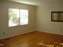 Bedroom featuring hardwood floors, window, and a mirror at 301 Briarcliff Dr, Dunn, NC 28334