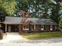 Charming single-story brick home with a well-manicured lawn and mature trees at 301 Briarcliff Dr, Dunn, NC 28334