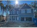 Stunning two-story home, blue siding, stone accents, and a two-car garage at 448 Little River Dr, Zebulon, NC 27597
