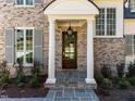 Stunning entryway with white columns, dark wood door, slate tile, and manicured landscape at 126 E Drewry Ln, Raleigh, NC 27609