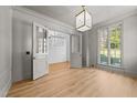 Open living room with hardwood floors, glass french doors, white trim, and abundant natural light at 126 E Drewry Ln, Raleigh, NC 27609