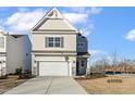 Two-story house with beige siding, stone accents, and a two-car garage at 182 Ford Meadows Dr, Garner, NC 27529