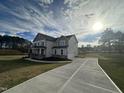 Spacious home featuring a long driveway and well-maintained lawn on a sunny day at 23 Quail Pt Cir, Clayton, NC 27520