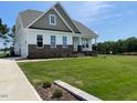 Inviting two-story home with brick accents and a lush green lawn, showcasing quality construction and design at 52 Quail Point Cir, Clayton, NC 27520