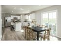 Open kitchen and dining area with stainless appliances, an island, and a dining table near sliding glass doors at 1585 Ivy Meadow Ln, Zebulon, NC 27597