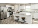Bright kitchen features white cabinets, granite countertops, stainless steel appliances, and a large island with seating at 1585 Ivy Meadow Ln, Zebulon, NC 27597