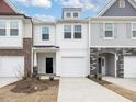 Charming townhome showcasing a light and airy exterior with a one-car garage and manicured front yard at 18 Clementine Street St # 207, Angier, NC 27501
