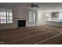 Open living room with a fireplace and large windows, seamlessly connecting to the kitchen area at 846 Cabin Creek Crk, Pittsboro, NC 27312