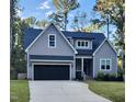 Front view of a gray, two-story house with a black garage door at 209 Choctaw Dr, Louisburg, NC 27549