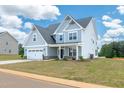 Charming two-story home featuring a light blue exterior, white trim, and an attached two-car garage at 443 Ravensworth Dr, Garner, NC 27529